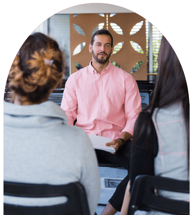 counselor speaks to two clients with their backs to the camera