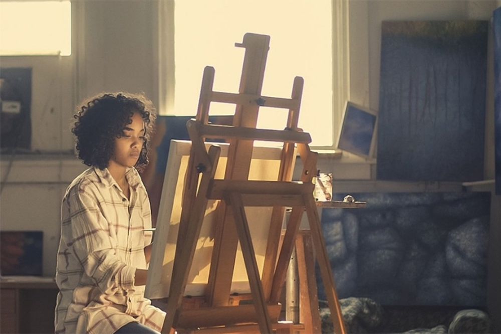 artist paints on easel