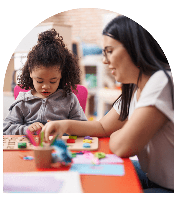 play therapy counselor talks to young child while working on a puzzle