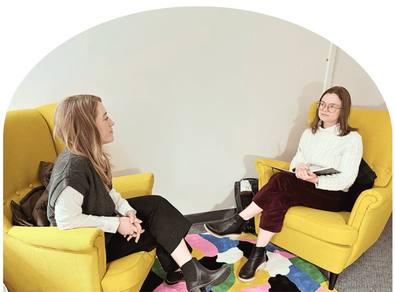counselor and client sit in yellow chairs in office during counseling session