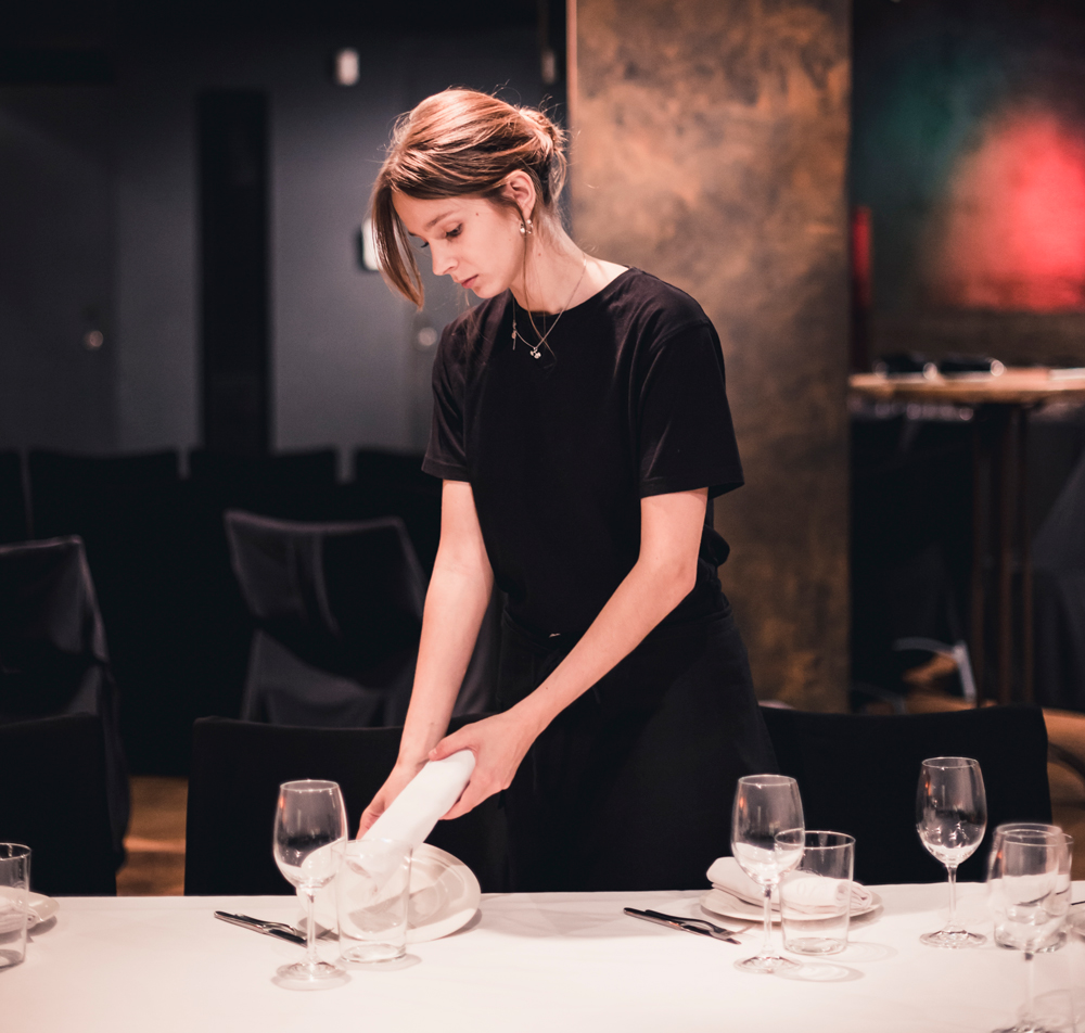 stock image of restaurant employee setting table