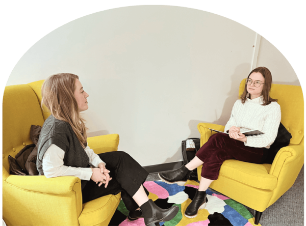 counselor and client sit in yellow chairs in office during counseling session